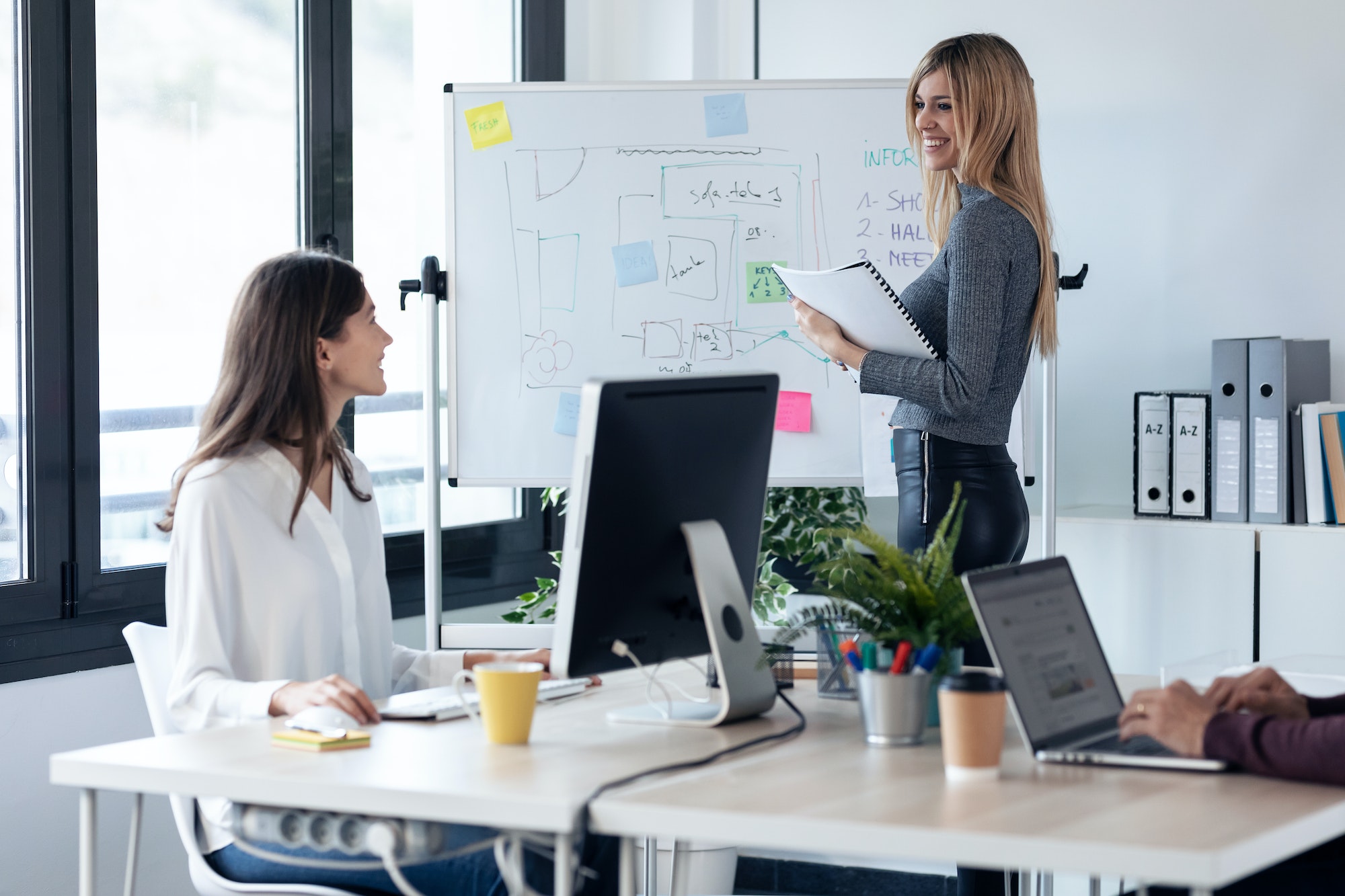 businessteam talking while explain a project to their colleagues in white blackboard