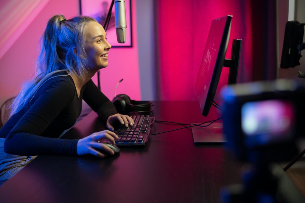 Professional esport gamer girl streaming vlog and plays online video game on PC